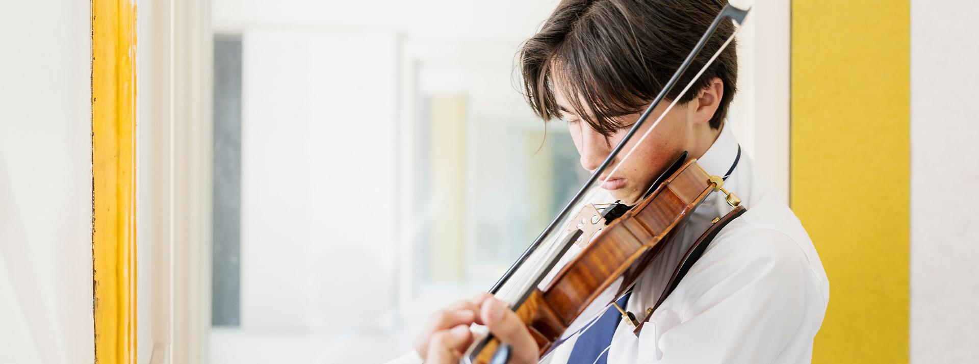 Student practising violin in music class at St Columba’s Catholic College Springwood