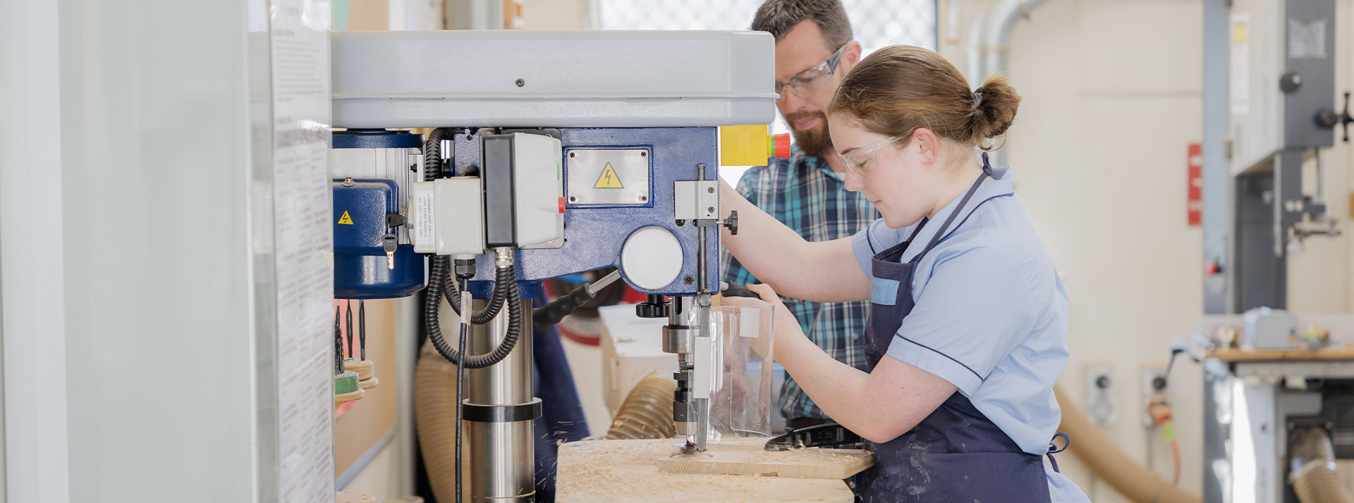 Teacher supervising his student on a woodworking machinery in class at St Columba’s Catholic College Springwood