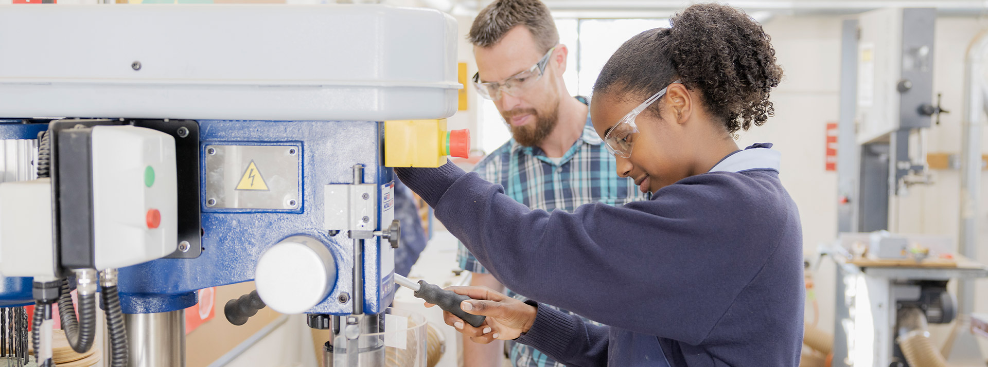 Teacher supervising his student on a woodworking machinery in class at St Columba’s Catholic College Springwood
