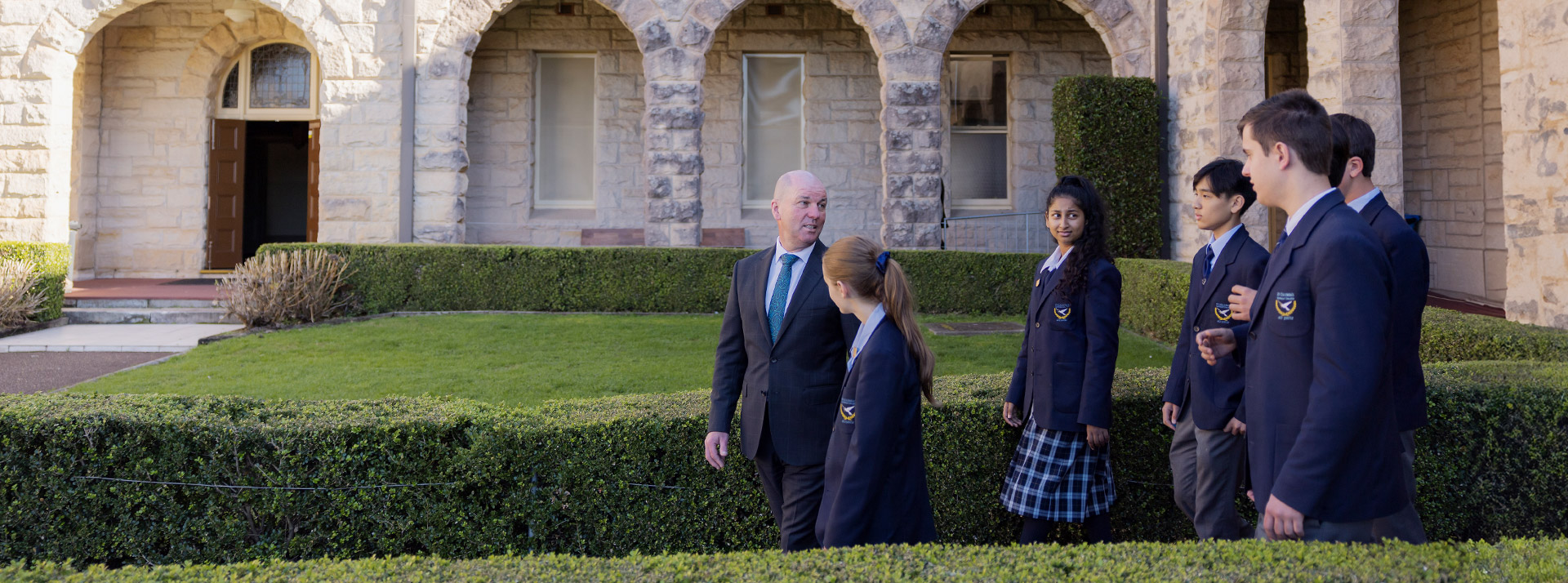 Students and their principal walking through the school grounds at St Columba’s Catholic College Springwood