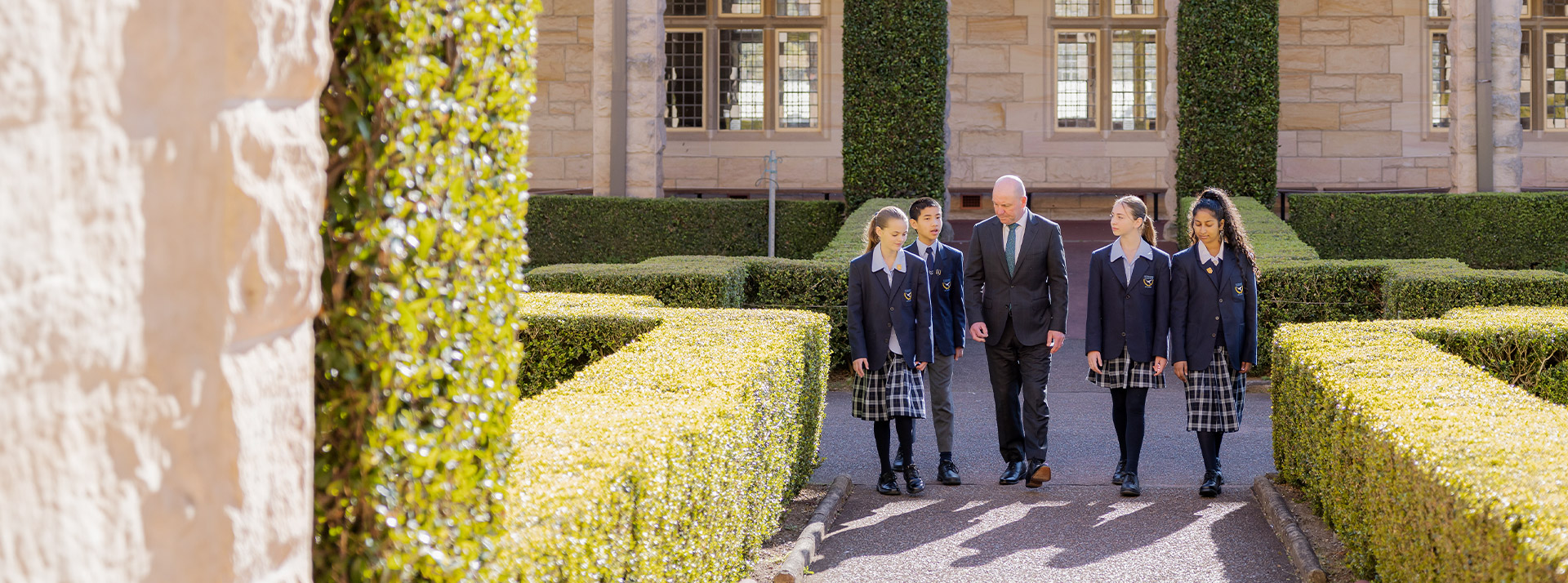 Students and their principal walking through the school grounds at St Columba’s Catholic College Springwood