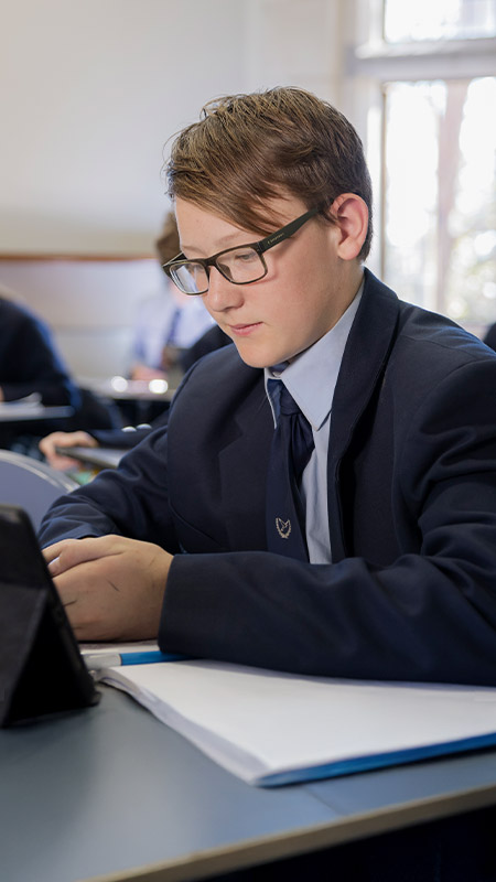 Student using his iPad in the classroom at St Columba’s Catholic College Springwood