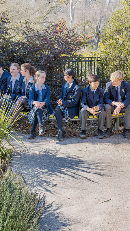 Students sitting together in the school grounds at St Columba’s Catholic College Springwood