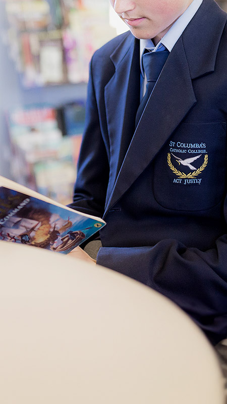 Student reading a book in the library at St Columba’s Catholic College Springwood