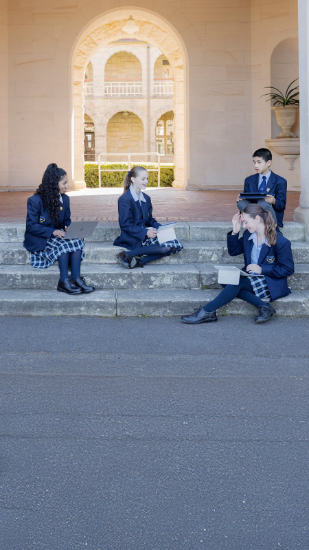 Students reading on the steps at St Columba’s Catholic College Springwood