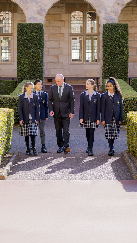 Students and their principal walking through the school grounds at St Columba’s Catholic College Springwood