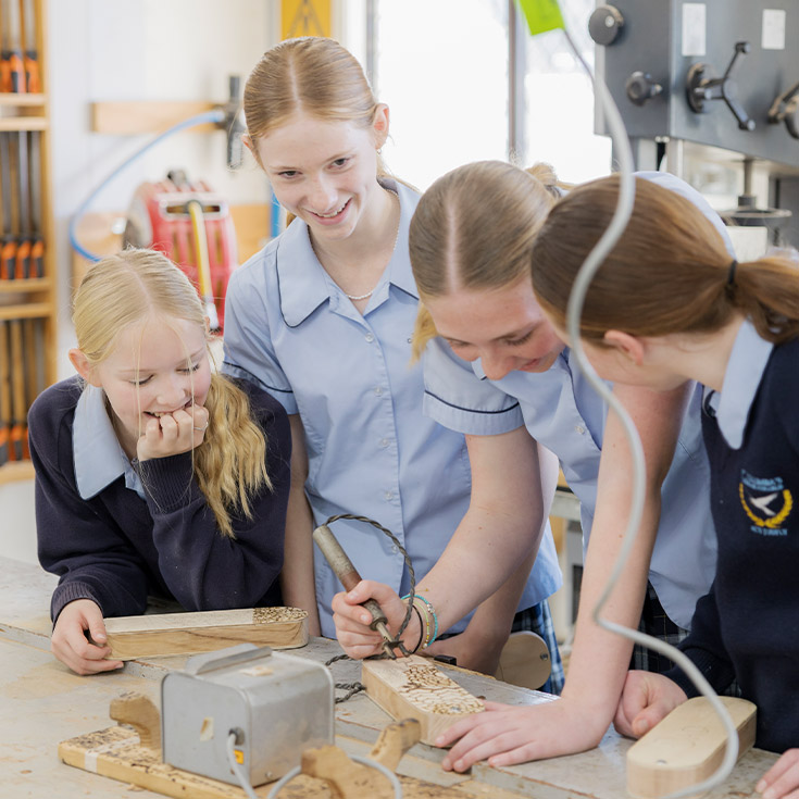 Students engraving timber in the woodwork room at St Columba’s Catholic College Springwood